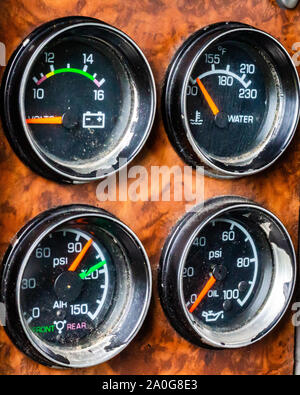Ein Dashboard in einem Lkw hat eine Reihe von schmutzigen und staubigen Manometer zeigt die Batteriespannung, Wassertemperatur, Luftdruck und Motoröldruck. Stockfoto