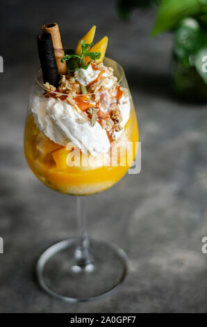 Bio Mango und Passionsfrucht tropische Eisbecher in Wein Glas Stockfoto
