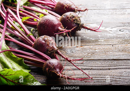 Frische organische Rote Bete auf Küche Holz- rustikalen Tisch Nähe zu sehen. Stockfoto