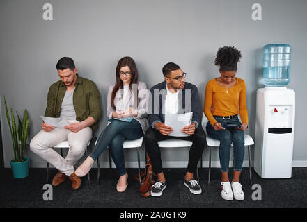 Multiethnischen Kandidaten warten auf das Vorstellungsgespräch im Wettbewerb für eine Position im Büro - vielfältige Gruppe von jungen Erwachsenen, die sich für eine Stelle Stockfoto