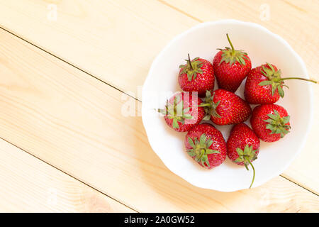 Süße Nachspeise für Raw-Diät. Schnelle veganen Snack aus frische und köstliche Erdbeeren in weiße Schüssel. Kopieren Sie Platz. Ansicht von oben. Stockfoto
