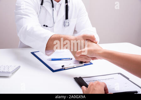 Männlicher Arzt Händeschütteln mit weiblichen Krankenschwester in der Klinik Stockfoto