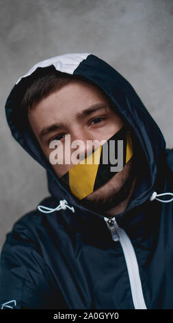 Mann mit Klebeband über den Mund. Der Mund ist mit Band abgedichtet Stockfoto