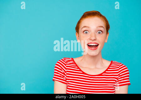 Portrait von Nizza cute attraktive mädchenhafte stilvoll trendy schockiert verrückt rothaarige Mädchen mit Bun, t-shirt, öffnete den Mund, über teal Vergangenheit isoliert Stockfoto