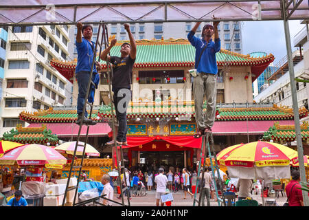 Arbeitnehmer gegenüber Kwan Im Thong Hood Cho Tempel, einem viel besuchten chinesische Tempel in Waterloo St., Singapur, das Dach eines Festzelt Stockfoto