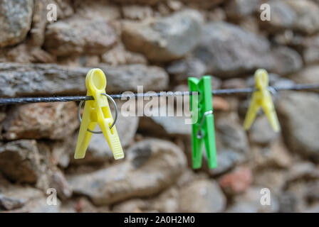 Diagonale bunten Kunststoff leer Wäscheklammern hängt das Seil im Außenbereich. Selektive konzentrieren. Stockfoto