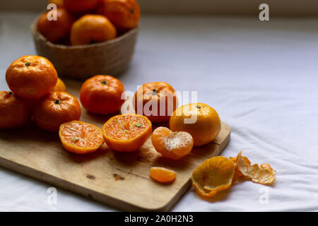 Stilllebenfoto mit frischen Clementinorangen, um das Konzept von Gesundheit, Ernährung, sauberem Leben und gesundem Lebensstil zu zeigen Stockfoto