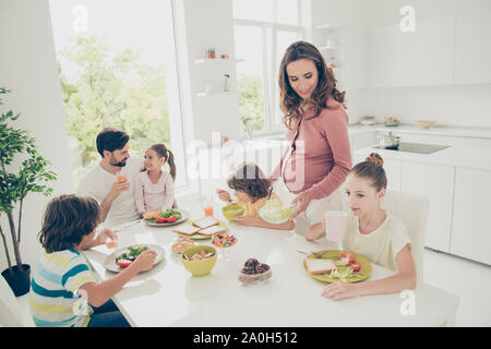 Große schöne bezaubernd schöne Adoptiveltern fröhliche fröhliche Familie, sechs Personen, Abendessen, Mittagessen, nützliche vegetarische Salat, knusprige Toasts, vegs, Süßigkeiten Stockfoto