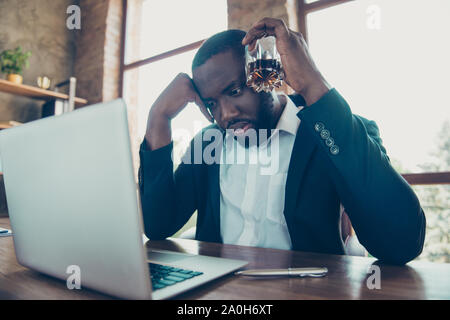 Low Angle View an eleganten und stilvollen Professional Business Hai, mulato Mann in der Jacke mit Weinglas bärtig, Mühen, Überprüfen der Bericht in der lapt Stockfoto