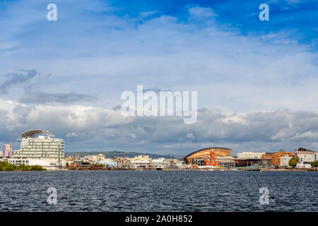 Eine Welle von Sonnenlicht leuchtet das Millennium Centre und roten Backstein Gebäude von Ikonischen waterfront Pierhead in Cardiff Bay, Glamorgan, Wales, Großbritannien Stockfoto