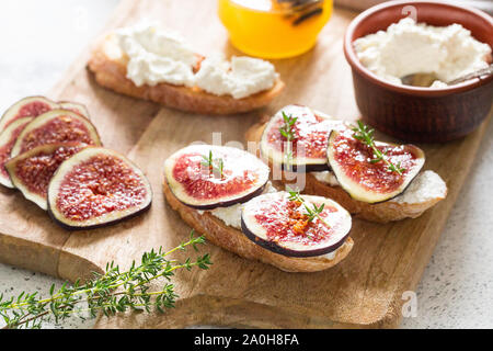 Ciabatta oder Bruschetta mit Frischkäse, Feigen und Honig. Sandwich mit Feigen und Ziegenkäse. Stockfoto