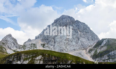 Panorama der westlichen Wand des Monte Mangart mit Wanderern in den Julischen Alpen. Von Mangart Sattel, Mangartsko sedlo Schießen. Grenze zwischen Slowenien und Italien Stockfoto