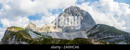 Die westliche Wand des Monte Mangart (2677 m) mit den Wanderer in die Julischen Alpen. Blick von mangart Sattel, Mangartsko sedlo. Grenze zwischen Slowenien und Italien. Stockfoto