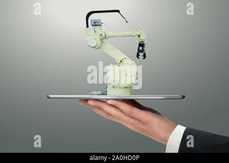 Mann mit einem digitalen Tablet mit Handling Roboter mit Roboterarm. Stockfoto