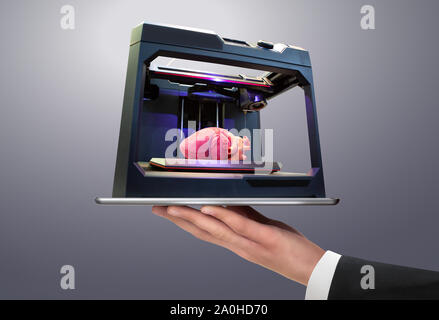 Mann mit einem digitalen Tablet-PC mit 3d-Drucker, der mit einem menschlichen Herzen gedruckt Stockfoto