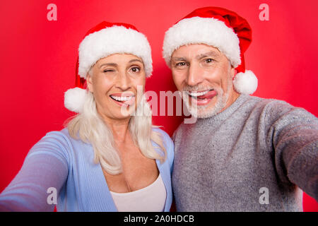 Selbstportrait von zwei netten kindlich verspielt verrückt Fröhliche positive froh grauhaarige Ehegatten Mann Frau Grimasse winking Blinkende genießen isoliert Stockfoto