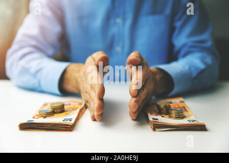 Finanz- und Budgetplanung Konzept - Geschäftsmann das Geld teilen auf dem Tisch Stockfoto