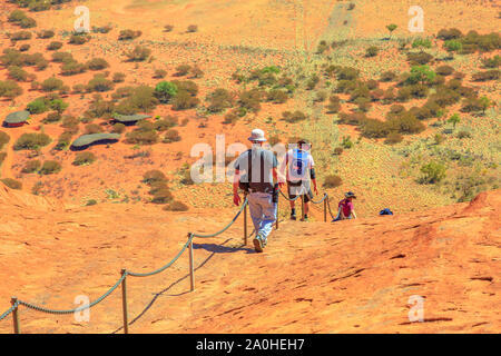 Uluru, Northern Territory, Australien - 23.August 2019: Kletterer in Uluru Kata Tjuta National Park hinunter gegen die Wünsche der Aborigines Stockfoto