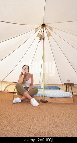 Junge Frau auf das Innere eines Camping Zelt Stockfoto