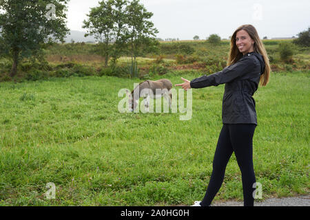 Junge Frau mit einem Esel auf einer Rasenfläche Stockfoto