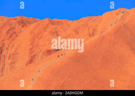 Uluru, Northern Territory, Australien - 26. Aug 2019: Bergsteiger besteigen den Uluru im Kata Tjuta National Park gegen den Willen der Urorigines Stockfoto