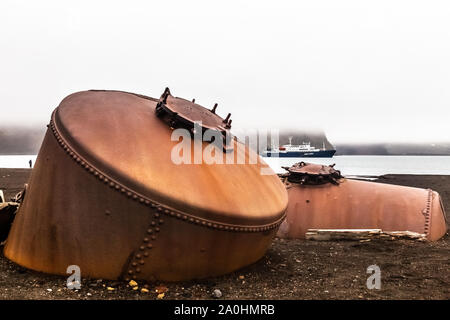 Verlassenen norwegischen Wal Jäger Bahnhof rostige blubber Tanks mit einem Kreuzfahrtschiff in der Bucht, auf Deception Island, Antarktis, 8. Stockfoto