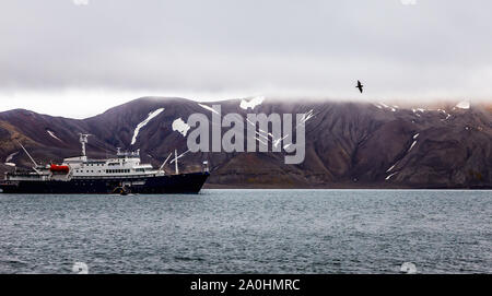 Touristische antarktis Kreuzfahrt nach Der schwarze Vogel in der lagoonwith Felsen von Deception Island, Antarktis Stockfoto