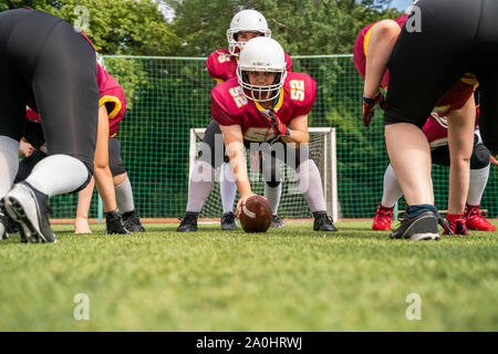 Foto von sportlichen Frauen spielen American Football auf grünem Rasen im Sommer Tag Stockfoto