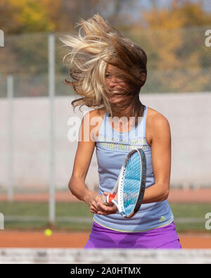 Frau mit Haar weht auf ihrem Gesicht warten auf Ball, Tennis spielen Stockfoto