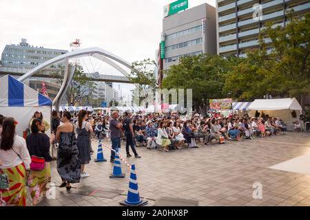 Chiba, Japan, 04/01/2019 Aloha Festival in Chiba Central Park im Sommer 2019. Die Leute sitzen auf Stühlen, die Teilnahme an der Veranstaltung, die Sie beobachten die zeigen. Stockfoto