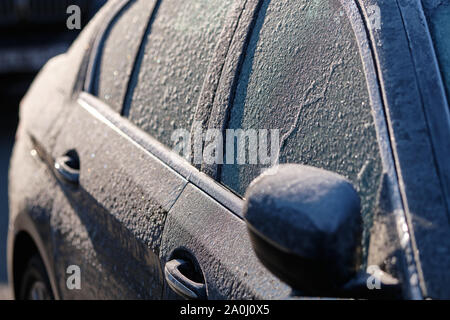 Detail einer gefrorenen Auto an einem kalten, sonnigen Winter morgen bedeckt mit Eis Stockfoto