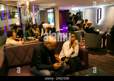 Johannesburg, Südafrika - 10. Dezember 2014: Jugendliche trinken Whisky aus einem tumbler Glas in der Zigarrenlounge Stockfoto