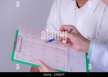 World Heart Day. Arzt Hände mit elektrokardiogramm Chart mit Pen. Kardiologe erklärt seinen Patienten EKG Ergebnisse. Stockfoto