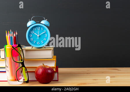 Zurück auf die Schulbank - Apple und Bücher mit Bleistifte und Brillen über blackboard. Stockfoto
