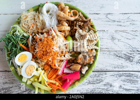 Som tum oder Papaya Salat in n weiße Platte auf hölzernen Hintergrund Stockfoto