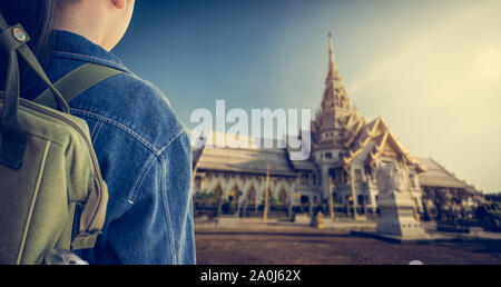 Mädchen mit Rucksack zu buddhistischen Tempel betreten. Wat Sothonwararam, Provinz Chachoengsao, Thailand. Travel Concept. Stockfoto