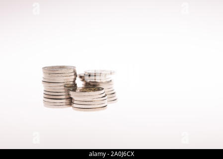Spalten mit goldenen Münzen auf weißem Hintergrund. Das Ergebnis erhöht. Stockfoto