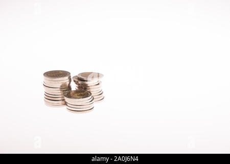 Spalten mit goldenen Münzen auf weißem Hintergrund. Das Ergebnis erhöht. Stockfoto