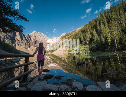 Frau, die auf der felsigen Küste des Lake Agnes in den Bergen. Stockfoto