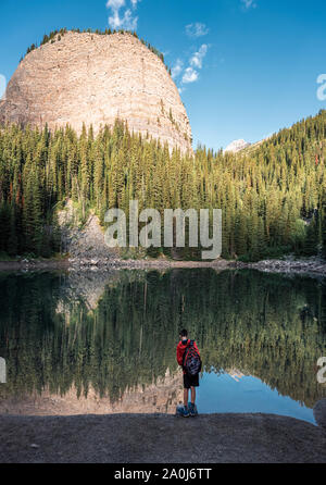 Junge stehen am Rand der Mirror Lake in den Rocky Mountains. Stockfoto