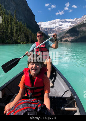 Mann und der Junge Kanu fahren auf dem Lake Louise, Alberta, Kanada auf. Stockfoto