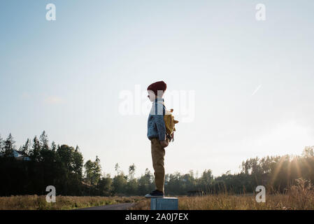 Junge Schule Junge stand auf einem Post spielen und wandern Home Stockfoto