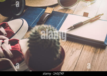 Pen und Notebook mit persönlichen Accessoire auf Holztisch. Travel Concept. Stockfoto