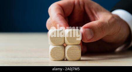 Hand eines Geschäftsmannes stapeln vier leere Holz Würfel auf einem Schreibtisch in einem konzeptionellen Bild. Stockfoto