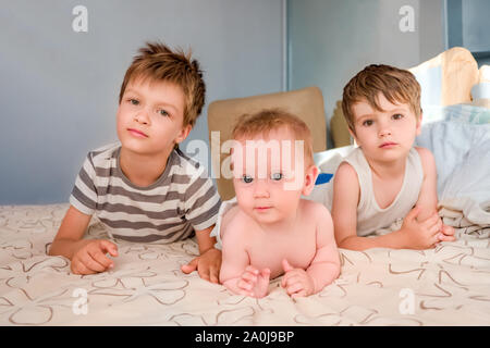 Geschwister Hintergrund. Drei Kinder in einer Familie. Die familiären Beziehungen. Brüder und Schwester Hintergrund. Happy Family Konzept. Schöne Kinder. Kaukasische Kinder schauen mit Interesse. Stockfoto