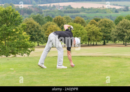 Ein Golfspieler bereitet sich auf T-Stück weg. Stockfoto