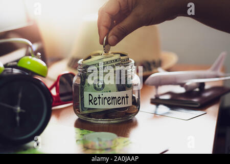 Hand der Leute holding Münzen in Glas. Konzept Geld Sparen für den Ruhestand. Das Finanzkonzept. Stockfoto