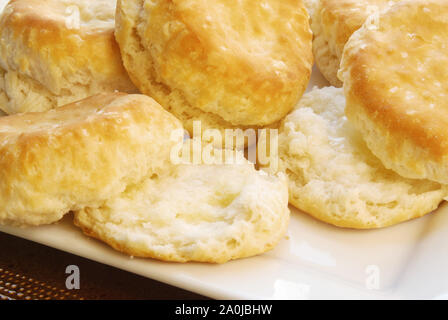 Hausgemachte gebackene südlichen USA buttermilk Biscuits mit zerlassener Butter auf die, die in Scheiben geschnitten sind. Stockfoto