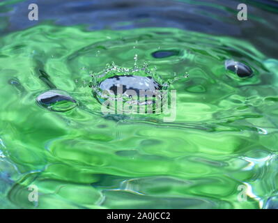 Splash und Wellen in eine grüne Flüssigkeit Stockfoto