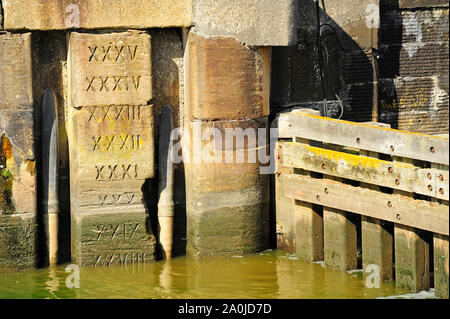 Römische Ziffern in Stein gemeißelt Wassertiefe Marker auf Docks Kai Stockfoto